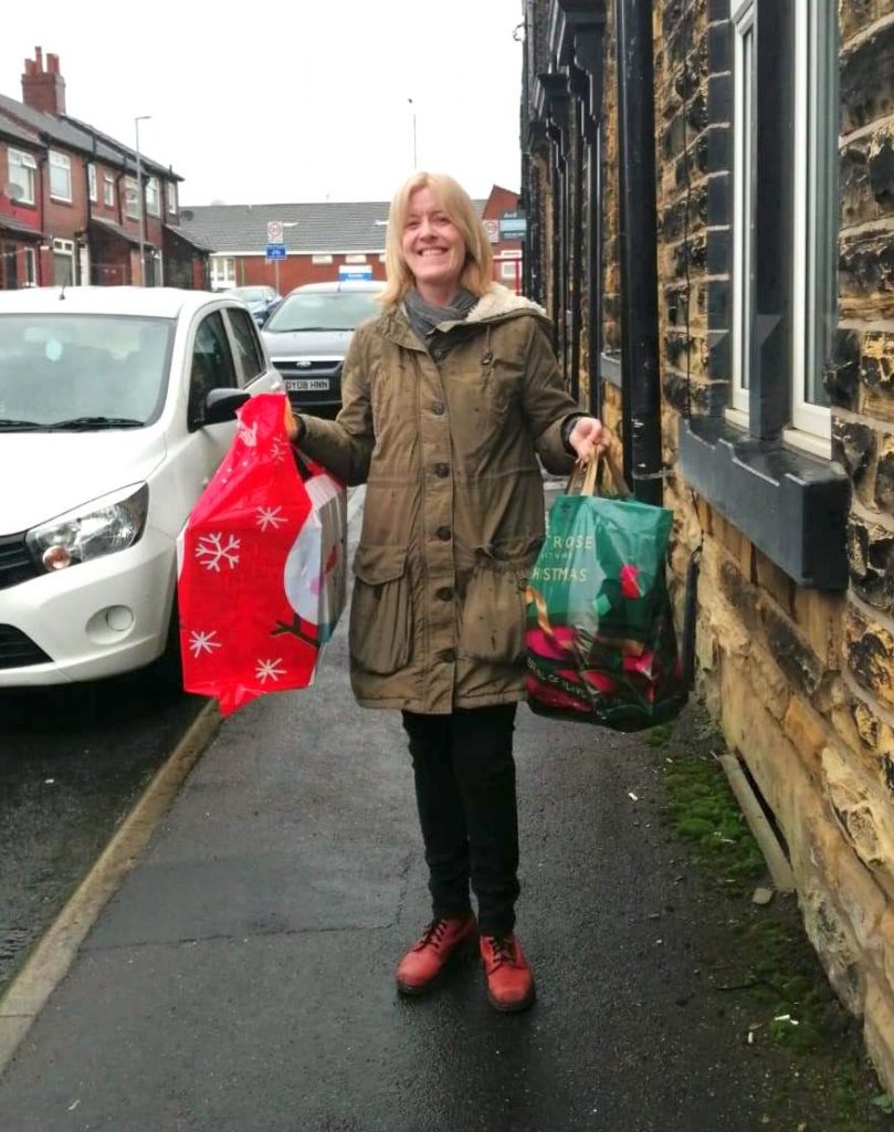 A volunteer dropping off gifts